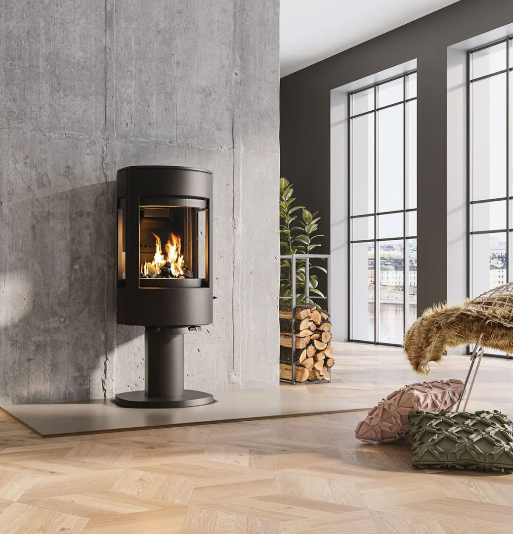 Peisovn bilde – moderne sort frittstående sylindrisk vedovn med koselige flammer i lys samtid stue hos Peisbutikken.no
